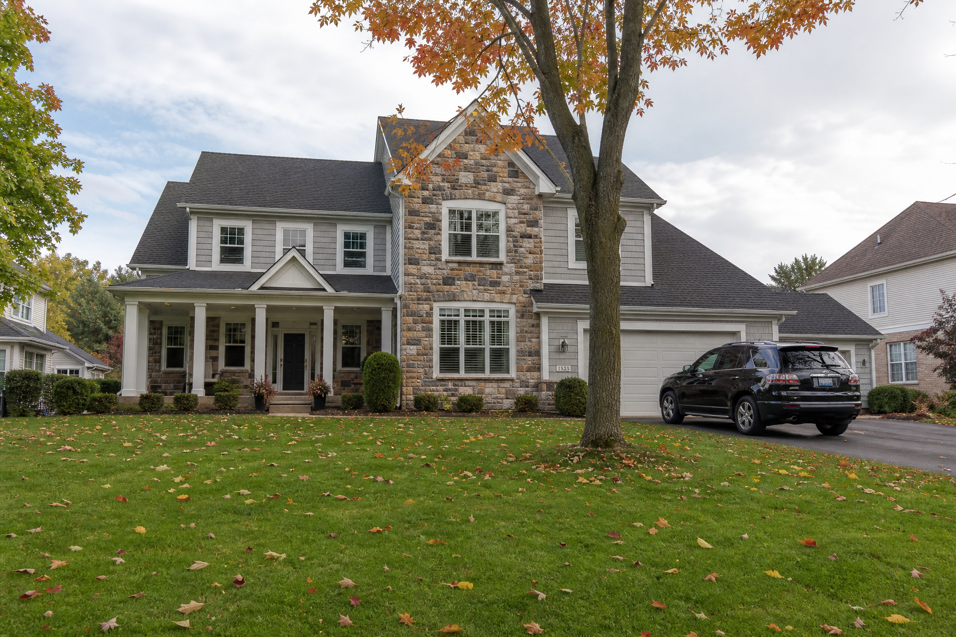 A classic Michigan home with a well-kept lawn and autumn leaves, representing the families and properties The Waligora Group protects